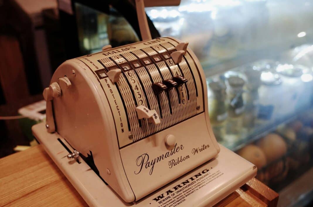 white paymaster ribbon writer adding machine placed on tabletop