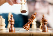 man holding chess piece