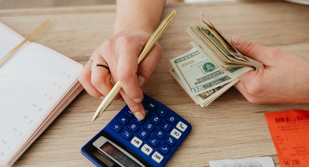 woman calculating money and receipts using a calculator
