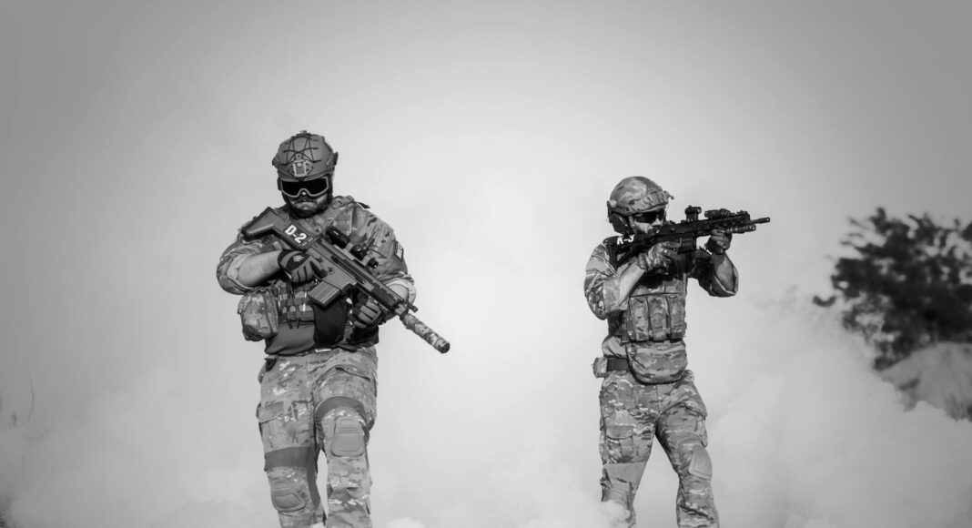 two men in military clothing with guns