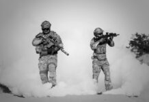 two men in military clothing with guns