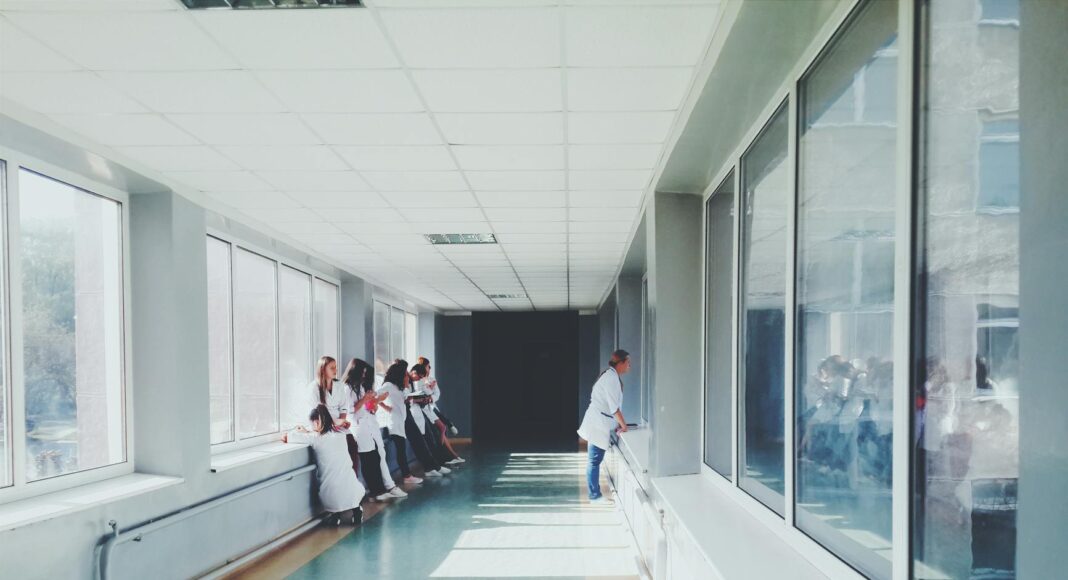 woman in white shirt standing near glass window inside room