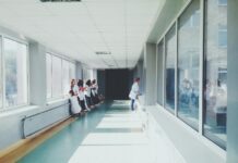 woman in white shirt standing near glass window inside room