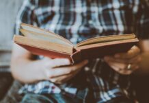 person reading book while sitting