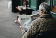 man sitting reading newspaper