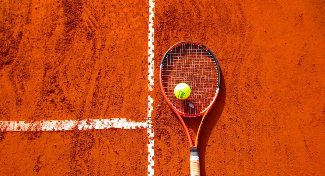 tennis ball on tennis racket on floor
