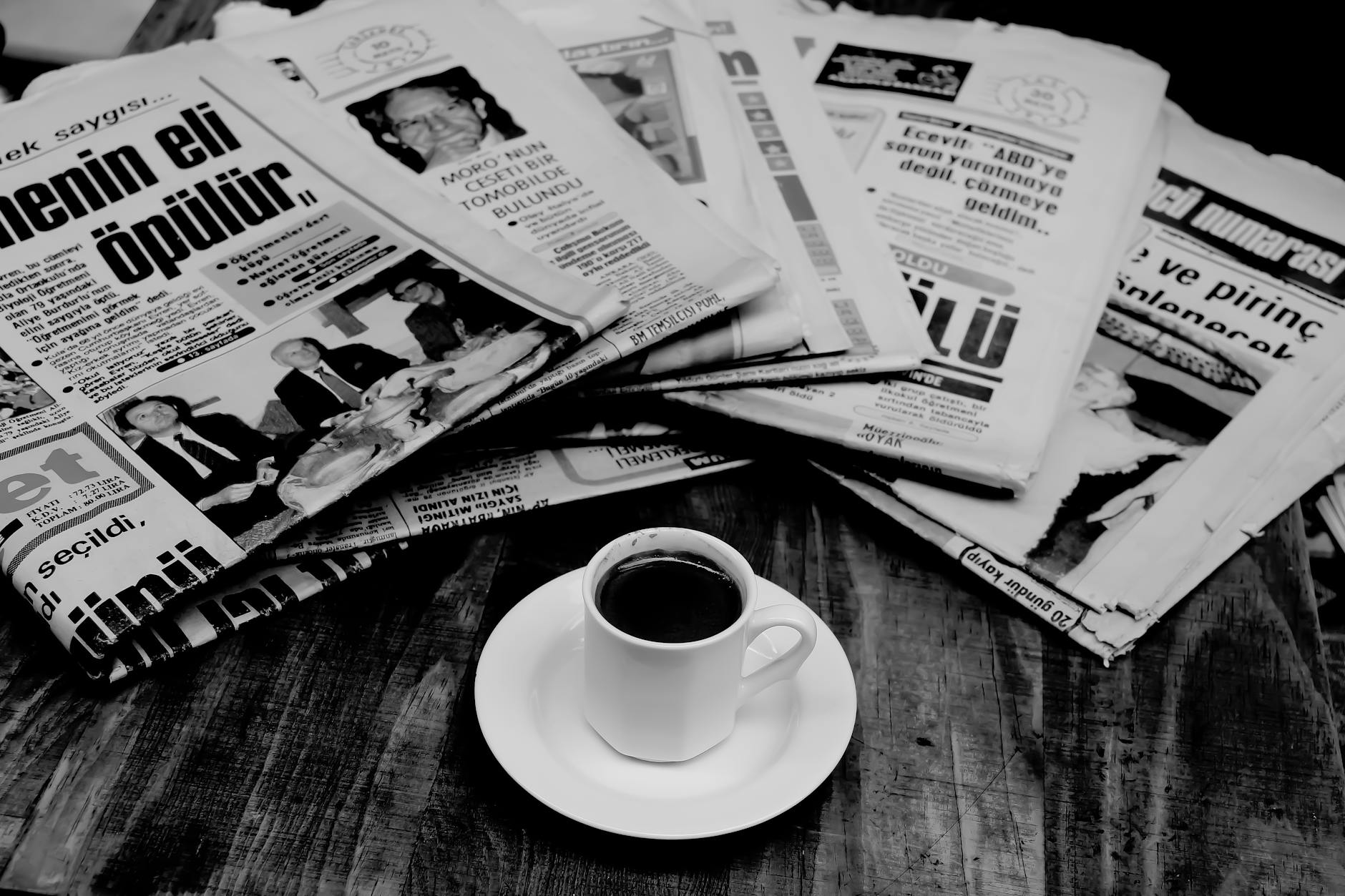 folded newspapers and a cup of coffee