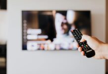 person pressing the button of a remote control