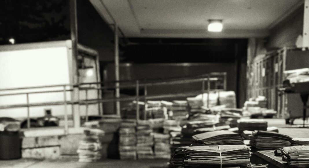 piles of bundled newspapers on a concrete floor