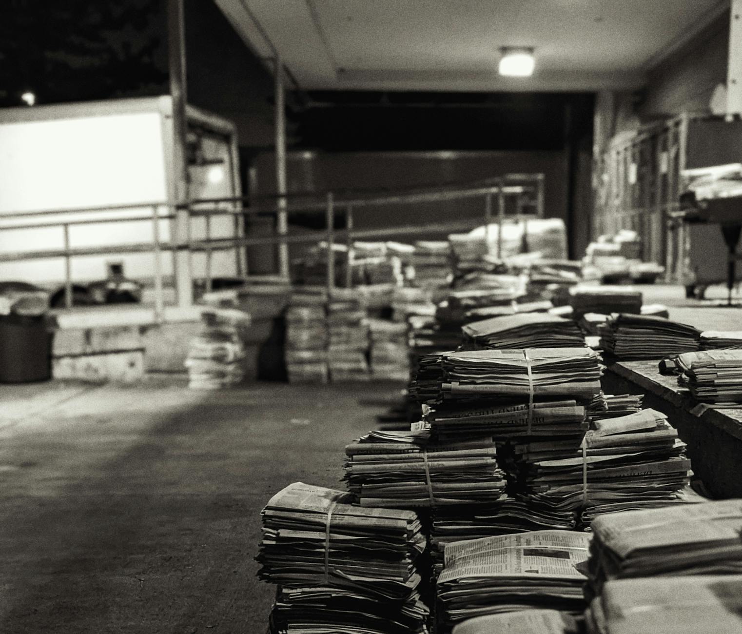 piles of bundled newspapers on a concrete floor