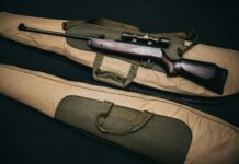 black rifle with scope and brown gig bag