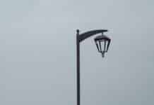 woman in black t-shirt and black shorts standing on gray concrete pavement near body of near near near near