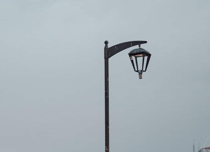 woman in black t-shirt and black shorts standing on gray concrete pavement near body of near near near near