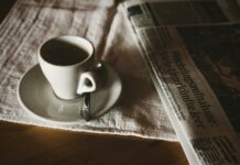 teacup on saucer near newspaper