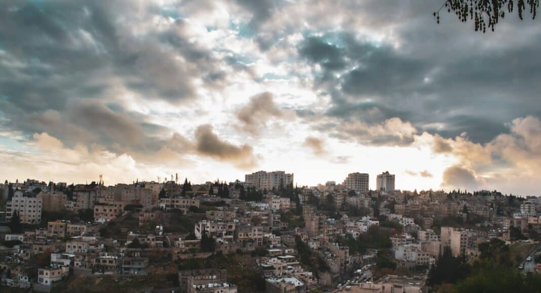 white and brown concrete buildings under white clouds during daytime