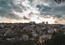 white and brown concrete buildings under white clouds during daytime