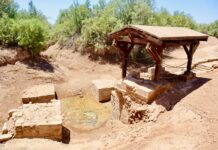 a well in the middle of a dirt field