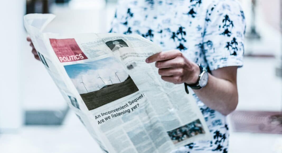 selective focus photography of person holding newspaper