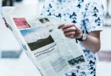 selective focus photography of person holding newspaper