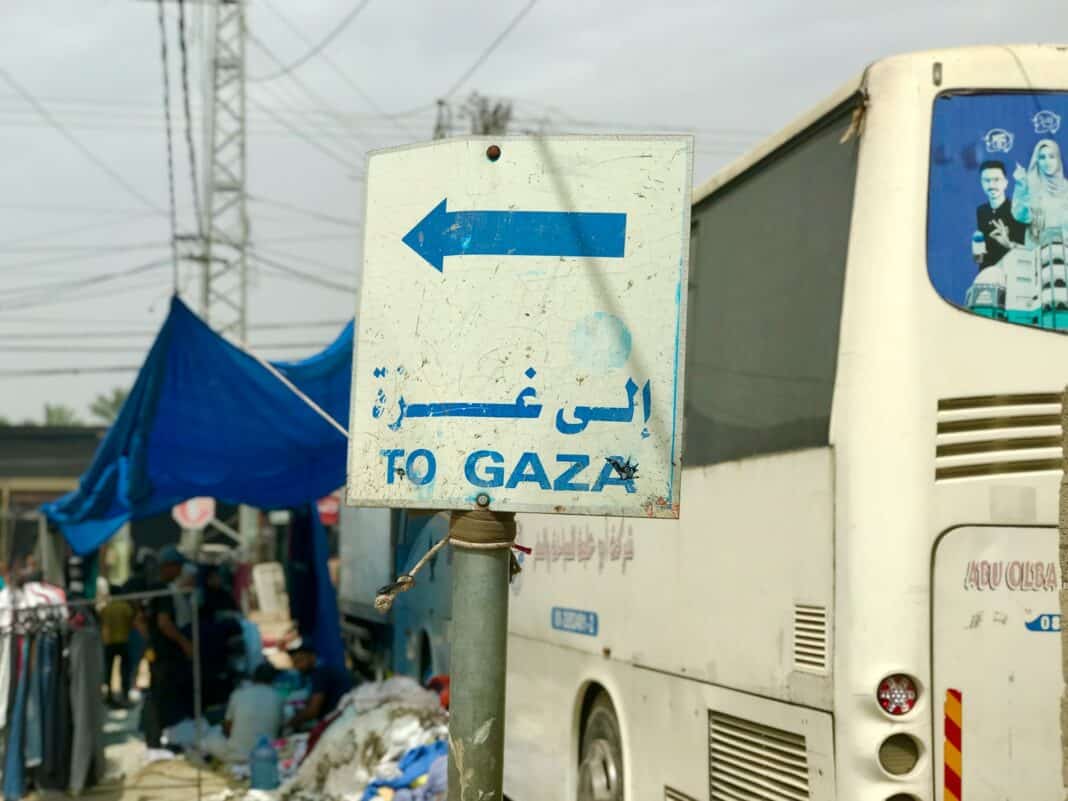 a white bus parked next to a blue and white sign