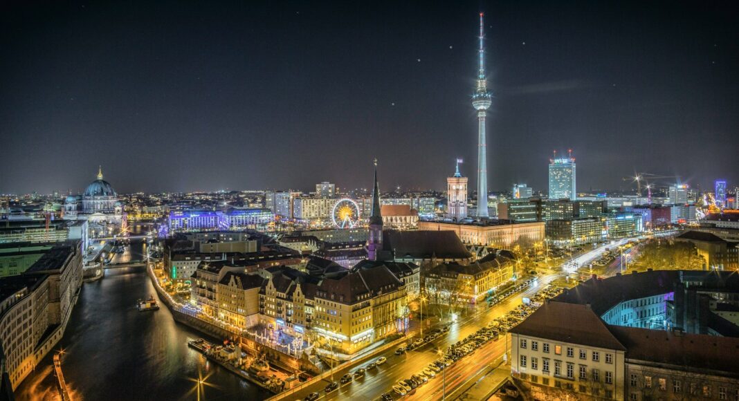 time-lapse photography of vehicle at the road in between the building at nighttime aerial photography