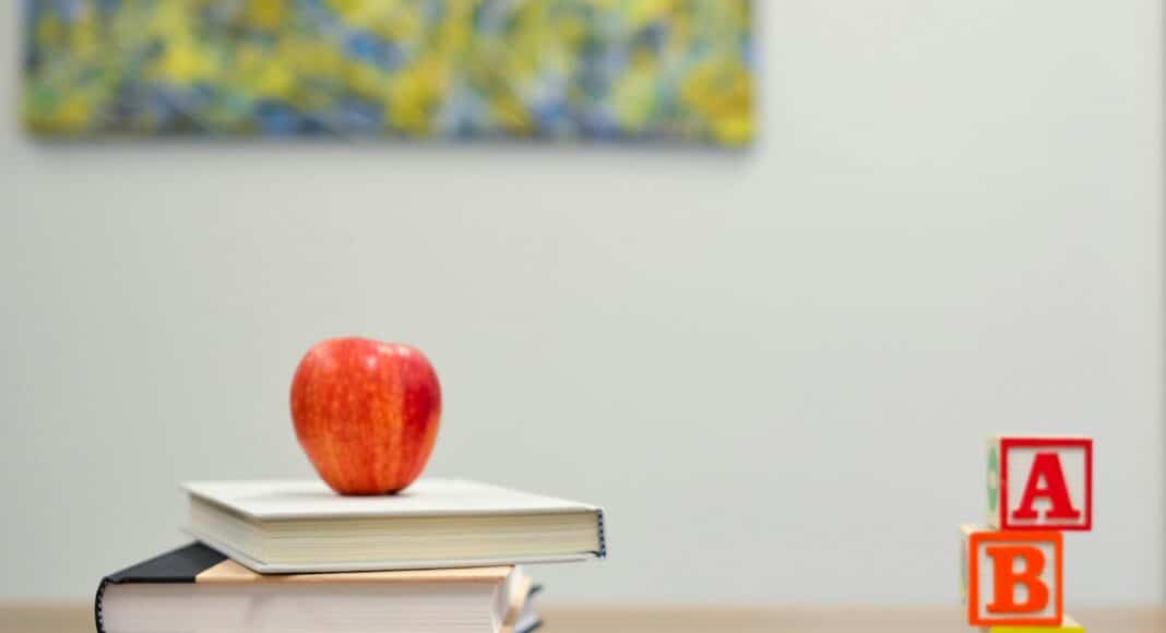 red apple fruit on four pyle books