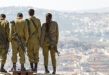 three men and one woman soldiers standing on rock during daytime