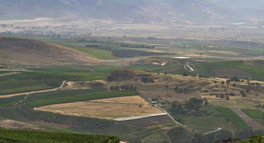 a scenic view of a valley with a winding road