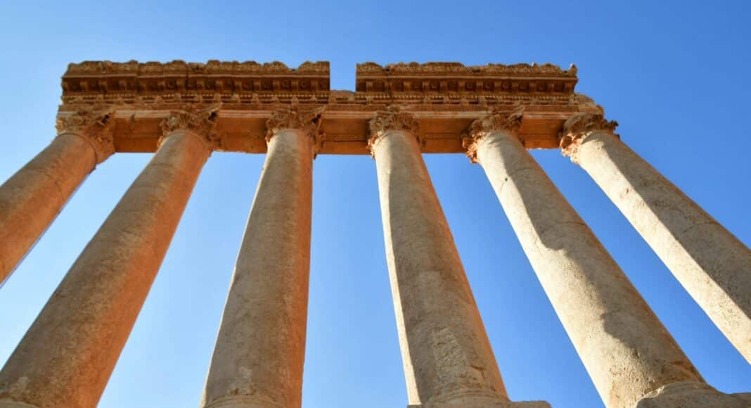 a group of tall stone pillars against a blue sky
