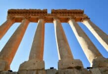 a group of tall stone pillars against a blue sky