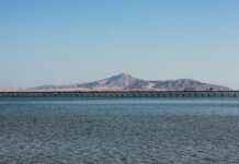 blue sea near mountain under blue sky during daytime