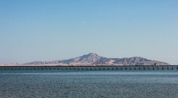 blue sea near mountain under blue sky during daytime