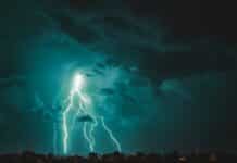 a lightning bolt striking over a city at night