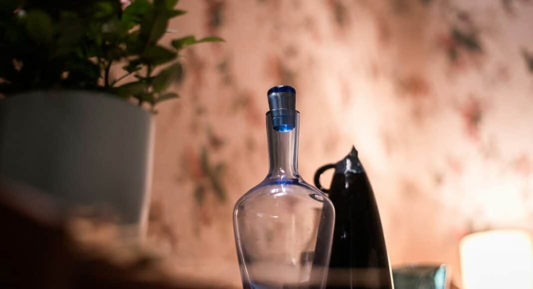 clear glass bottle on brown wooden table
