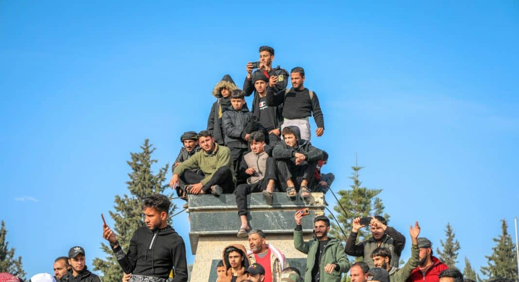 A group of people sitting on top of a monument