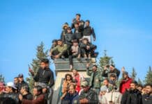Un ancien détenu libéré en Syrie soulève des interrogations au Liban A group of people sitting on top of a monument