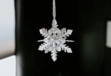 A snowflake ornament hanging from a window
