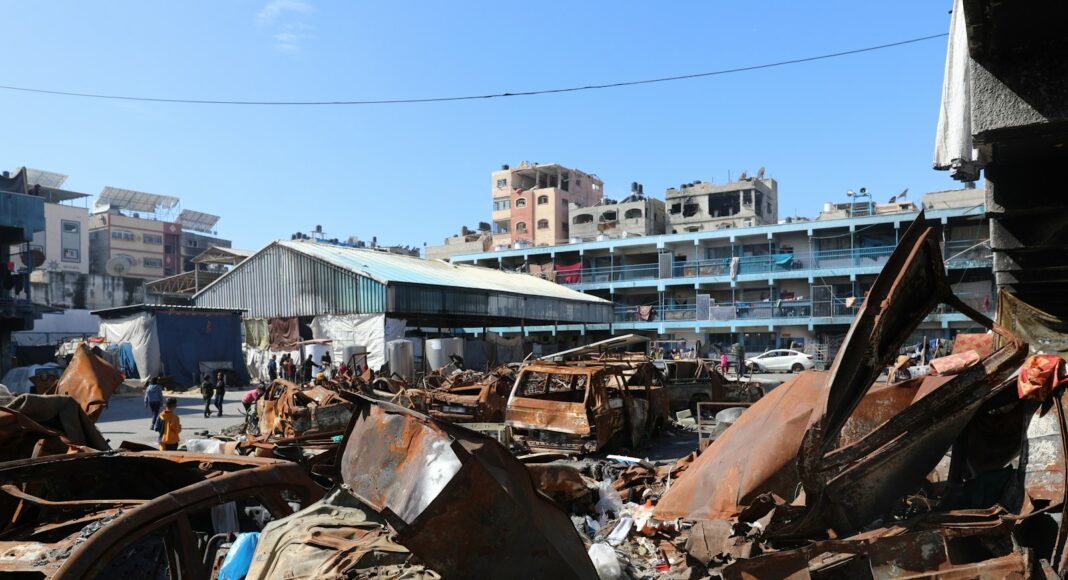 A man standing next to a pile of junk