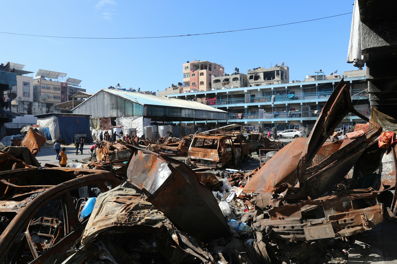 A man standing next to a pile of junk
