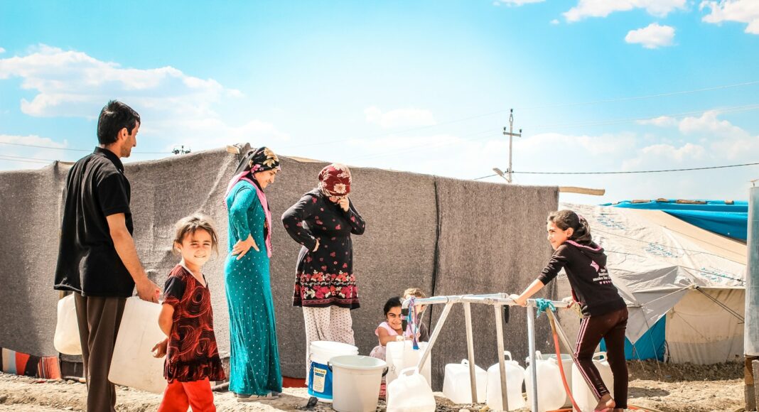 a group of people standing on top of a sandy beach