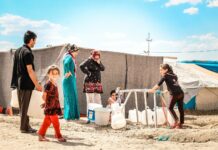 a group of people standing on top of a sandy beach