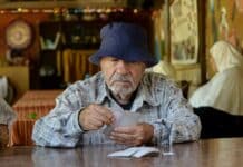 A man sitting at a table with a hat on