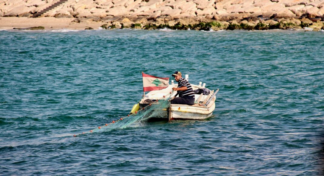 man wearing black and gray striped shirt sitting on white boat on blue body of water during daytime