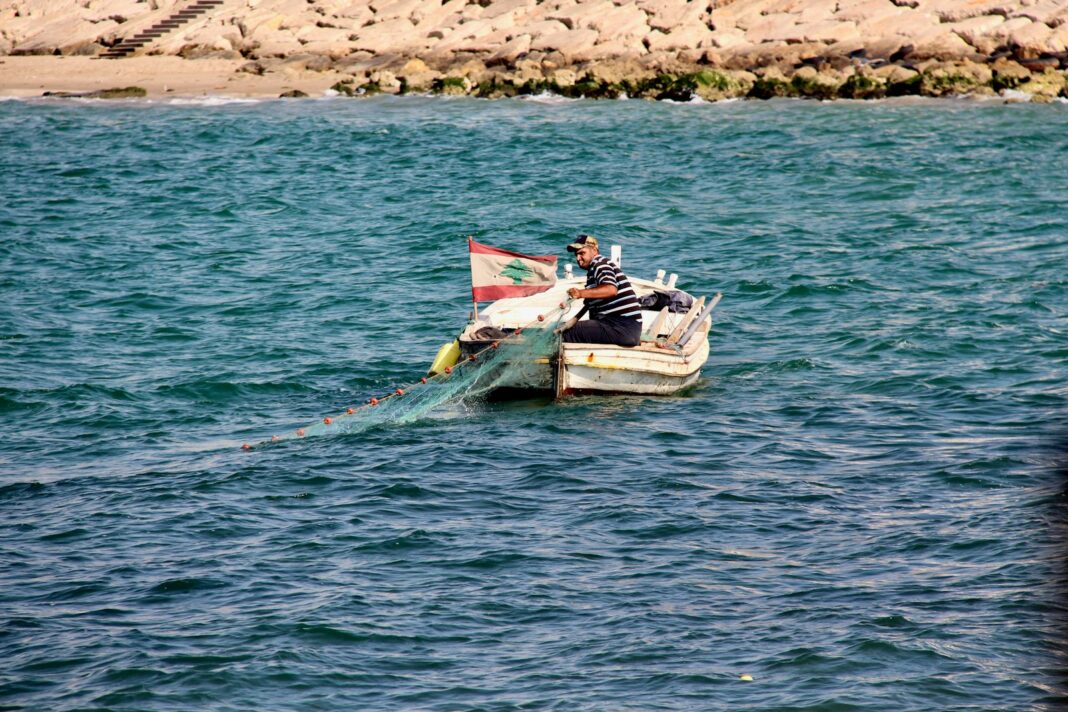 man wearing black and gray striped shirt sitting on white boat on blue body of water during daytime