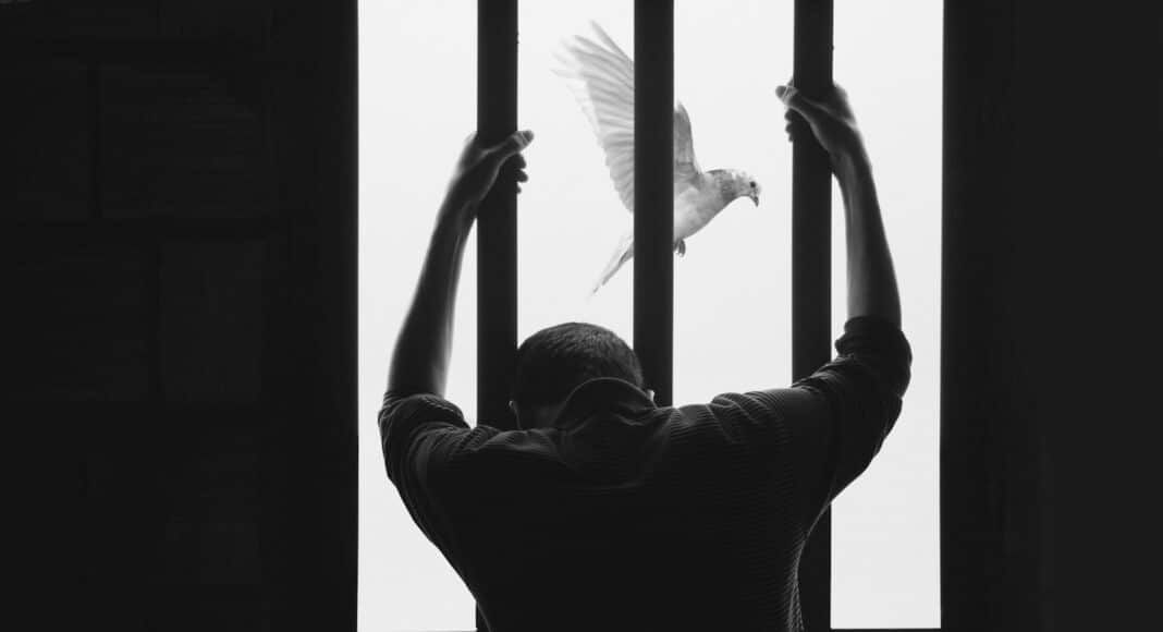 man in black long sleeve shirt raising his right hand