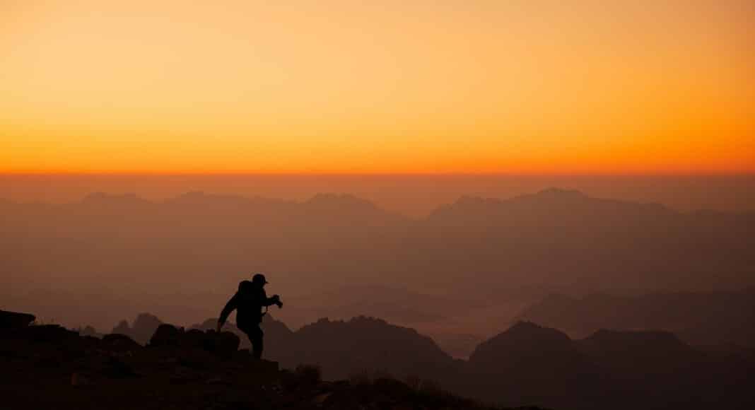 a person standing on top of a mountain at sunset