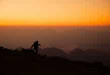 a person standing on top of a mountain at sunset