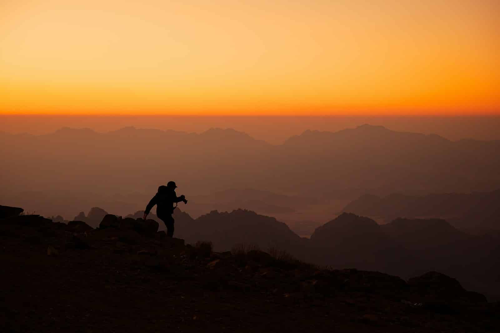 La transition énergétique au Moyen-Orient : une région en mutation face aux défis énergétiques a person standing on top of a mountain at sunset