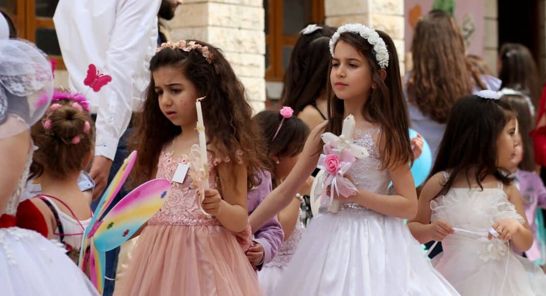 2 women in white dress holding hands