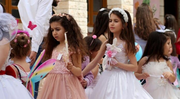 2 women in white dress holding hands